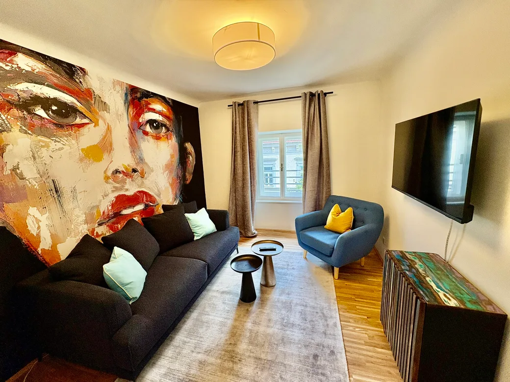 Wohnzimmer mit Wandkunst und blauem Sofa – The Blue One
